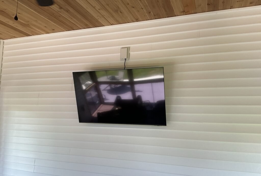 TV mounted on a siding wall in a covered porch